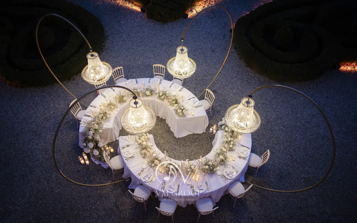 Aperitivo a Villa Subaglio: tavolo serpentina con lampadari di cristallo nel cortile