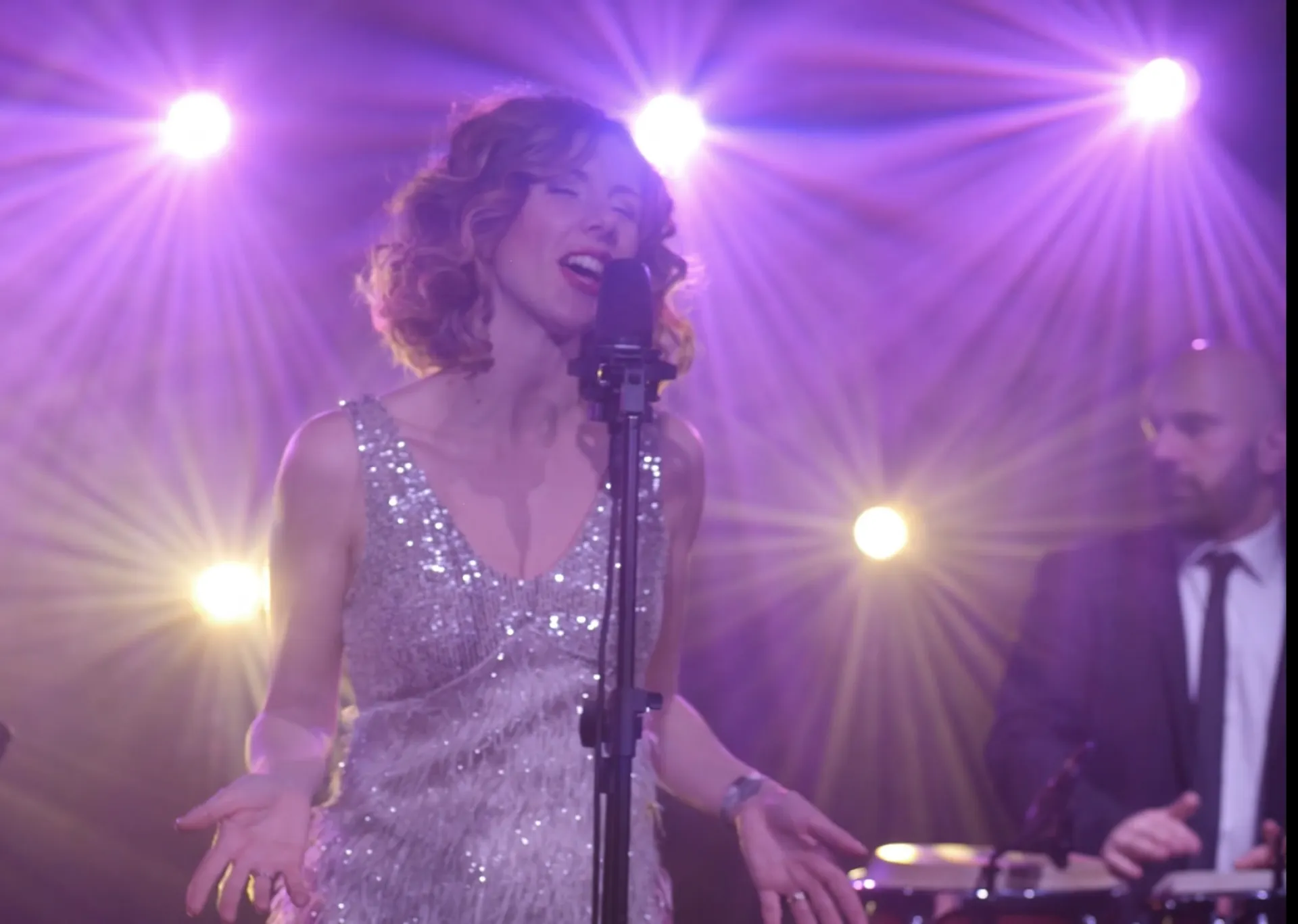 Cantante dal vivo con luci sceniche durante una performance serale (Victor Music)